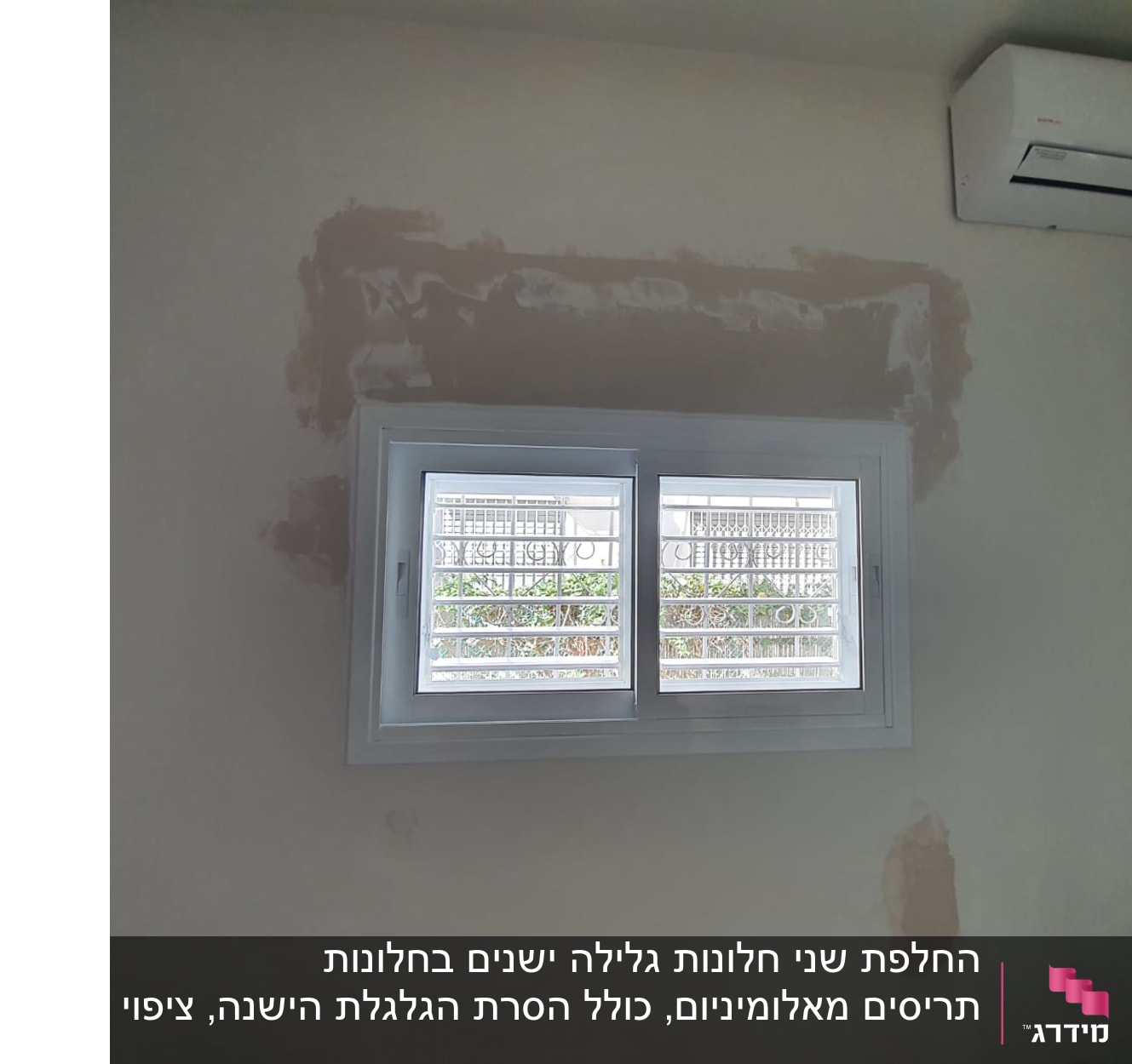 חלון אלומיניום עם סורגים על קיר לבן